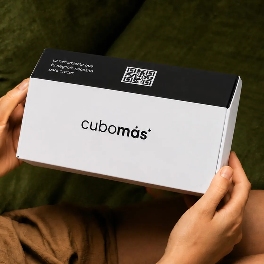 Manos sosteniendo la caja de un Cubo Más
