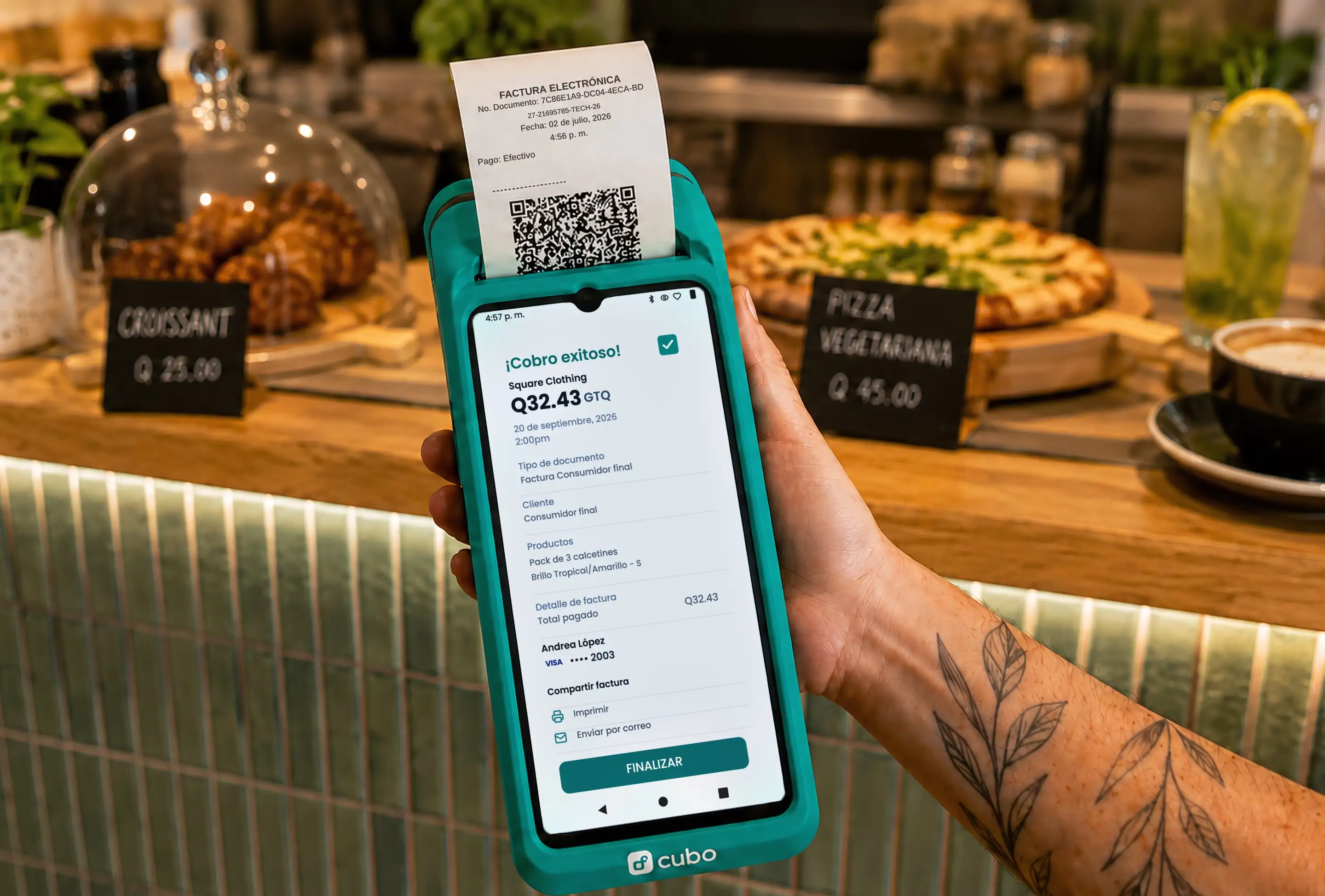 Mano sostiene una terminal Cubo que imprime una factura electrónica en una cafetería