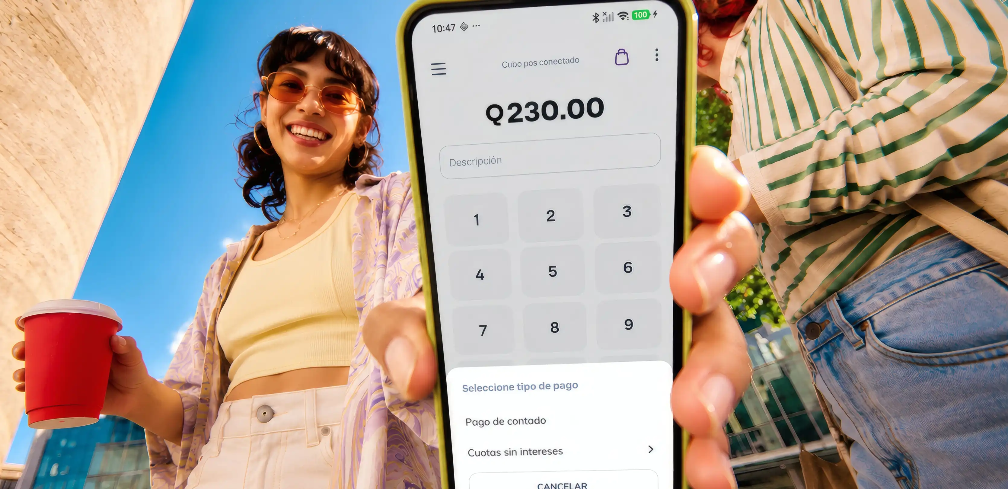 Una clienta sonríe junto a un celular con la app de Cubo que cobra Q230.00 y ofrece pagar en cuotas