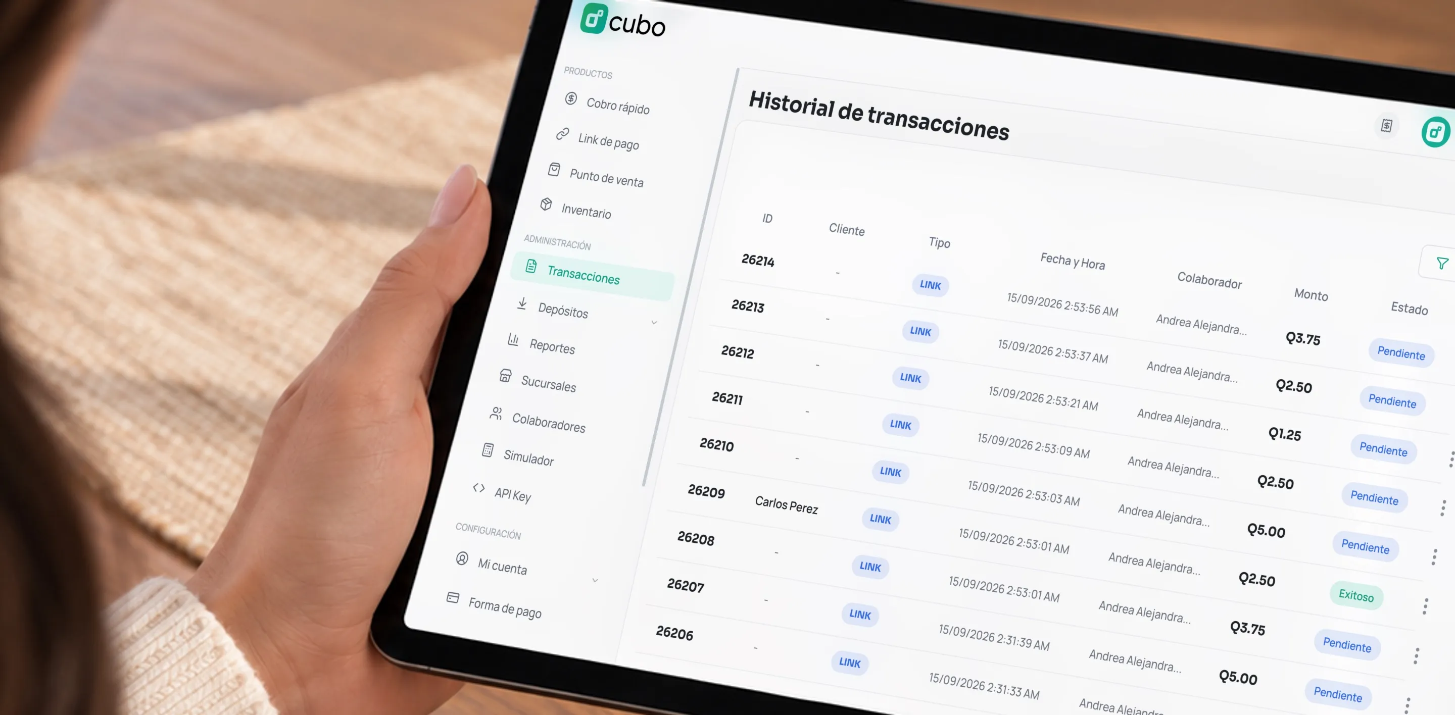 Manos sosteniendo una tablet con el historial de transacciones de Cubo en quetzales